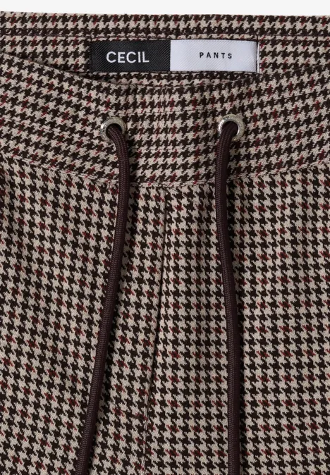Nahaufnahme einer Hose mit Hahnentrittmuster, Kordelzugbund und Markenlabel 'CECIL PANTS'.