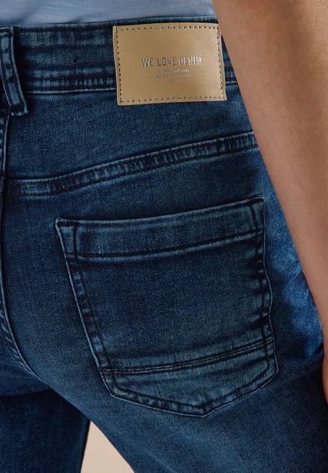Rückansicht einer dunkelblauen Jeanshose mit Tasche und Ledermarke am Bund