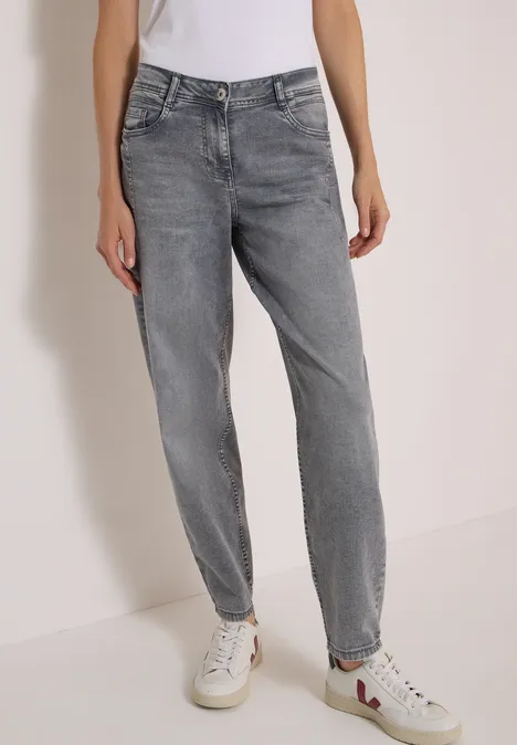 High Waist Barrel Leg Jeans w stylu Loose Fit light grey wash Szare, luźne jeansy z wysokim stanem, noszone przez osobę, zestawione z białymi trampkami.