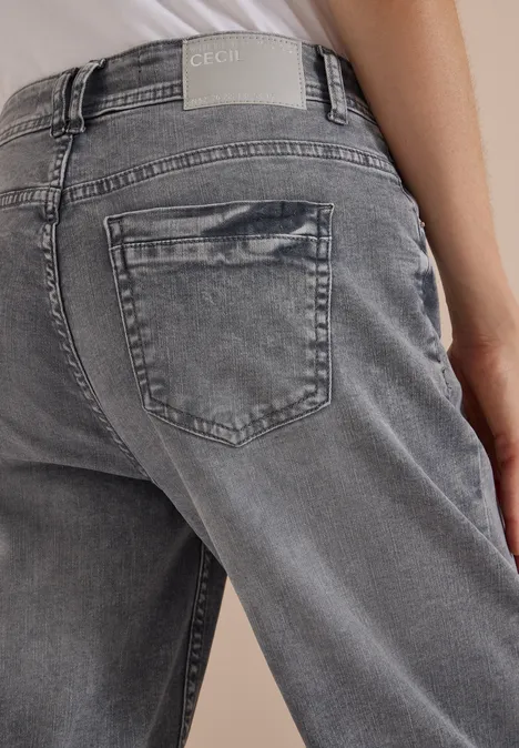 High Waist Barrel Leg Jeans w stylu Loose Fit light grey wash Widok od tyłu osoby w szarych dżinsach z tylną kieszenią i metką CECIL na pasie.