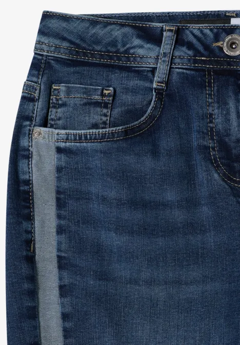 Nahaufnahme einer blauen Jeans mit Gürtelschlaufen, Fronttasche und Knopfdetail.