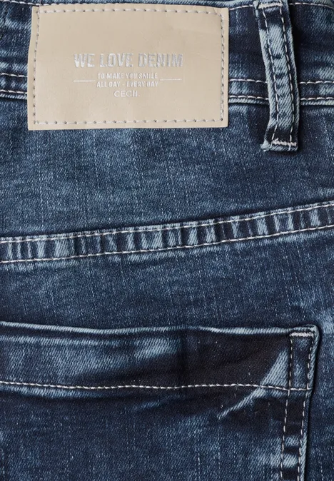 High Waist Bootcut Jeans im Slim Fit mid blue used wash Nahaufnahme einer blauen Jeanshose mit aufgenähter Leder-Patch mit Schriftzug "WE LOVE DENIM".
