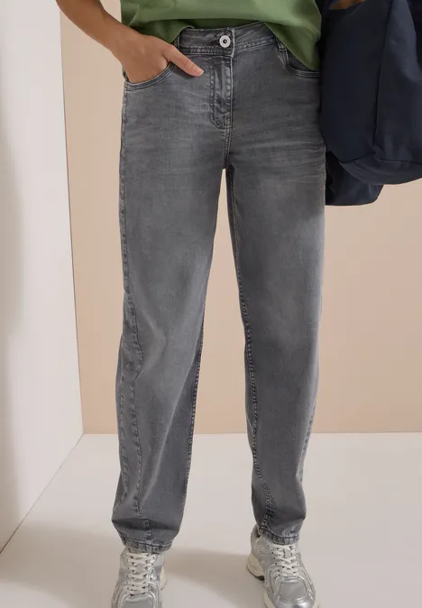 Gerade geschnittene graue Jeans mit Knopfverschluss, kombiniert mit weißen Sneakers.