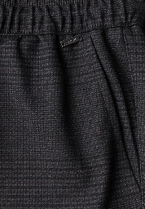 Detailaufnahme einer dunkelgrauen, gemusterten Hose mit elastischem Bund und seitlicher Tasche.