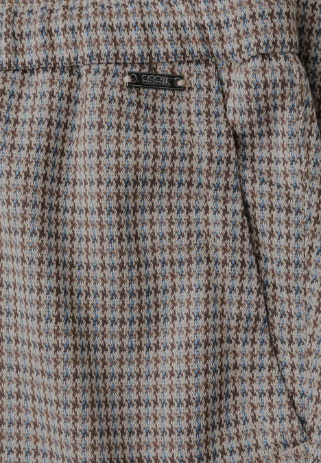 Nahaufnahme einer beige-grünen Hahnentrittmuster-Hose mit seitlicher Tasche.