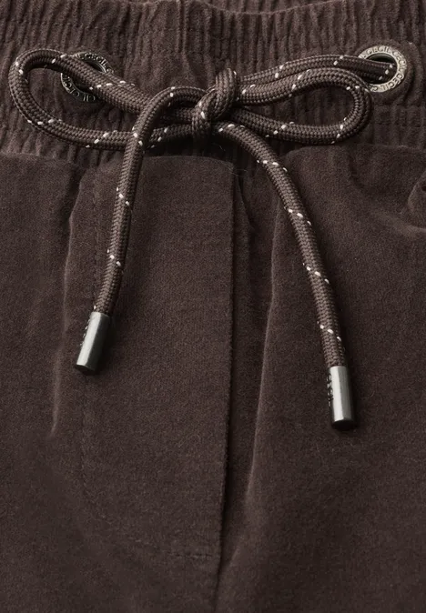 Braune Hose mit elastischem Bund und Kordelzug, die in einer Schleife gebunden ist.