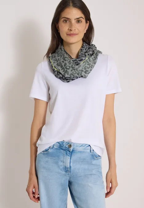 Frau in weißem T-Shirt, blauen Jeans und gemustertem Schal.