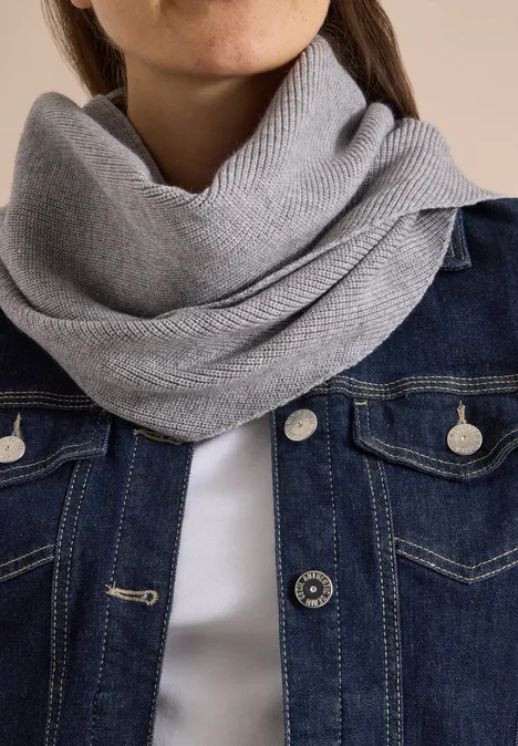Grauer Strickschal und Jeansjacke, Nahaufnahme von Hals und Oberkörper.