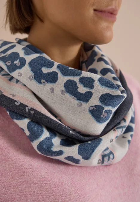 Dreieckstuch mit Leo-Muster dark navy blue Eine Frau trägt einen lässigen Loop-Schal mit blauem Leopardenmuster über einem rosa Pullover.