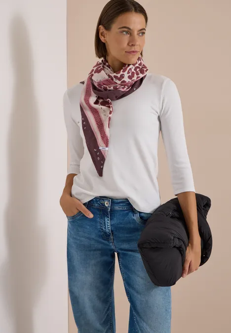 Dreieckstuch mit Leo-Muster berry red Frau in weißem Shirt, blauen Jeans und gemusterter Schärpe hält eine schwarze Jacke.