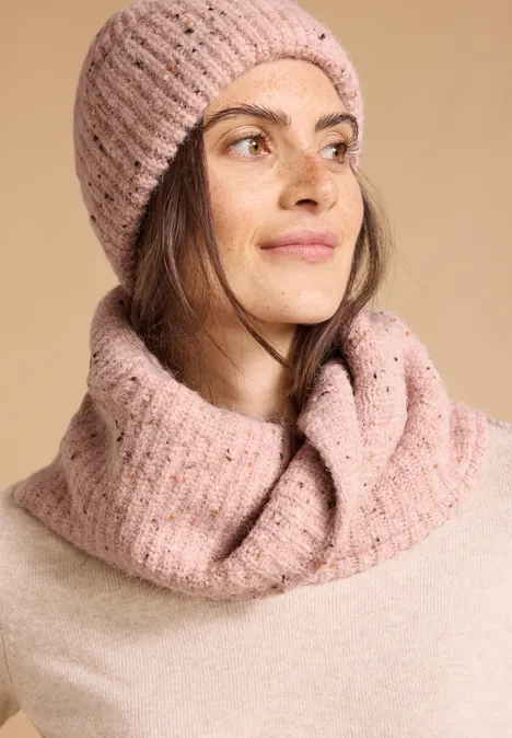 Loop-Schal mit Wollanteil und Melange-Muster neps rose fog melange Frau mit rosa Strickmütze und Loop-Schal, blickt lächelnd zur Seite.