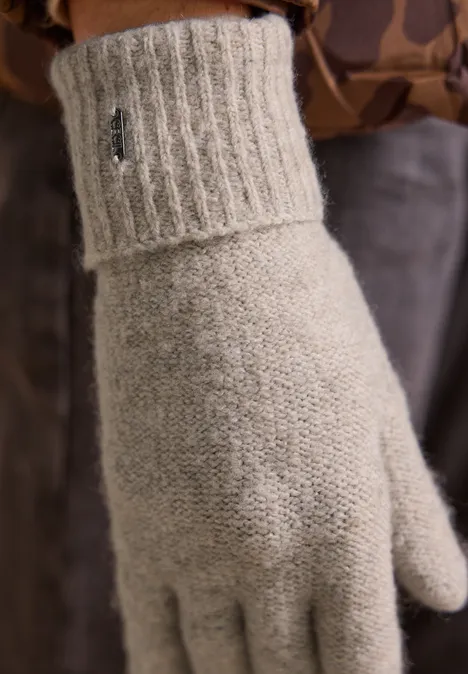 Ein hellgrauer gestrickter Wollhandschuh mit breitem Rippbündchen.