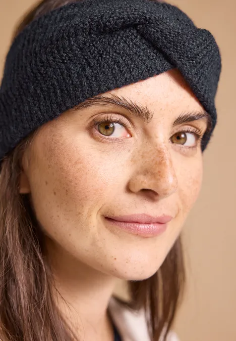 Stirnband in Melange-Optik dark navy blue Nahaufnahme einer Frau mit Stirnband, braunen Augen und leichter Sommersprossen vor warmem Hintergrund.