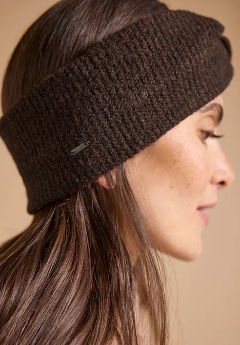 Stirnband in Melange-Optik choco sauce brown melange Seitliches Profil einer Frau mit braunem, dick gestricktem Stirnband vor beigem Hintergrund.