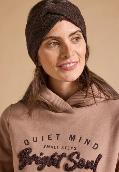 Stirnband in Melange-Optik choco sauce brown melange Frau mit braunem Stirnband und Hoodie lächelt nach rechts, Schriftzug 'Quiet Mind Small Steps Bright Soul'.