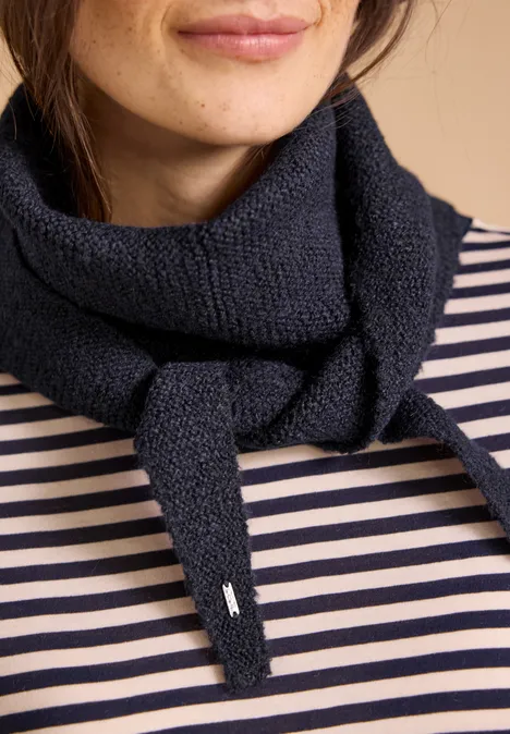 Eine Frau trägt einen schwarzen Strickschal über einem weiß-blauen Ringelshirt, nur Hals und Kinn sind sichtbar.