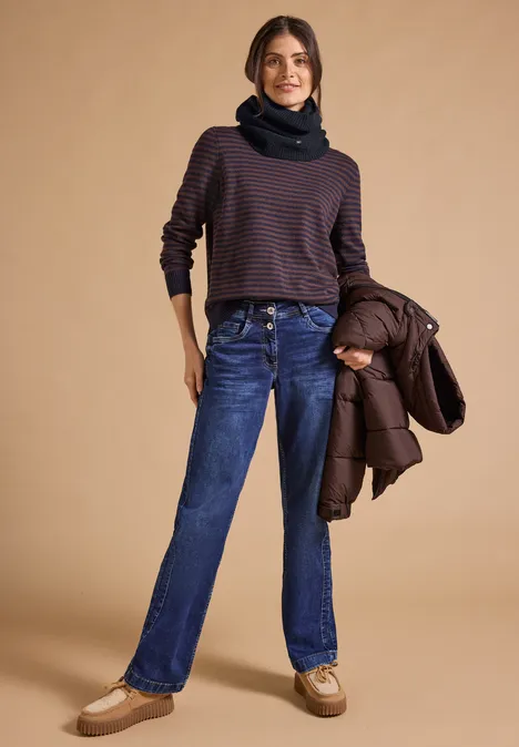 Loop-Schal in Melange-Optik dark navy blue Frau trägt gestreiften Pullover, Jeans, Schal, hält eine Jacke, steht lächelnd.