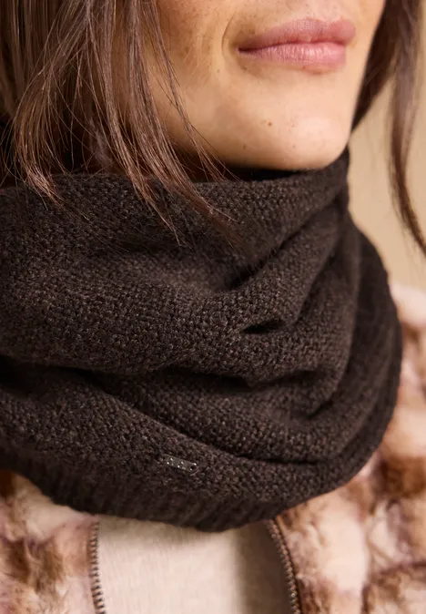 Loop-Schal in Melange-Optik choco sauce brown melange Teilansicht einer Person mit dunkelbraunem Strickschal und flauschiger Jacke.