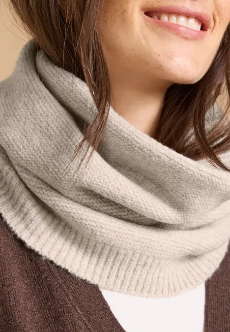 Loop-Schal in Melange-Optik powder beige melange Nahaufnahme einer lächelnden Frau mit beige gestricktem Schlauchschal über braunem Pullover.