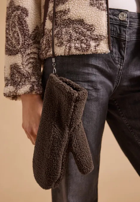 Fäustlinge im Teddy-Look chocolate sauce brown Braune Teddy-Plüsch-Umhängetasche in Handschuhform, kombiniert mit Jeans und Fleecejacke.