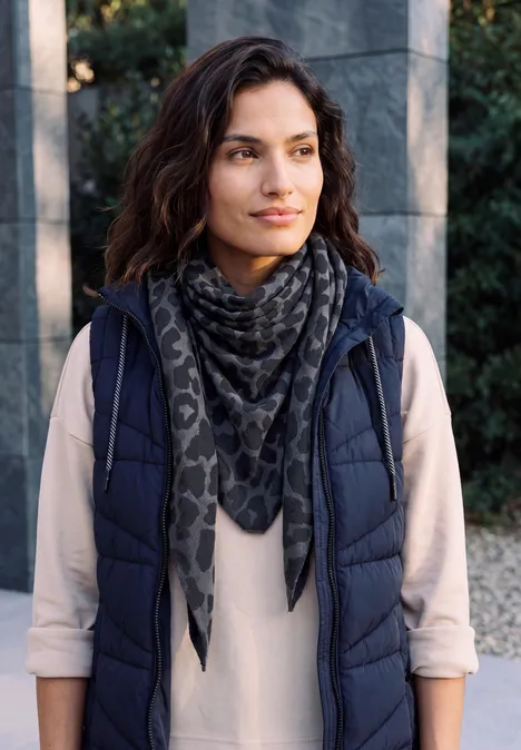 Foulard triangulaire à motif léopard dark navy blue Femme en doudoune bleu marine et foulard à motifs devant une façade moderne
