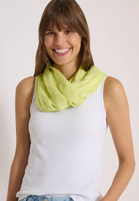 Effen Loop-sjaal citrin green Lächelnde Frau mit braunen Haaren, weißem Top und hellgrünem Schal.