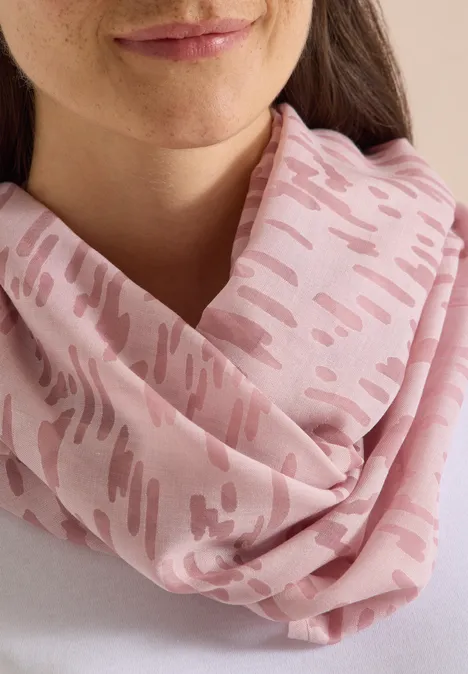 Rosa Schlauchschal mit abstraktem Pinselstrich-Muster, locker um den Hals getragen.