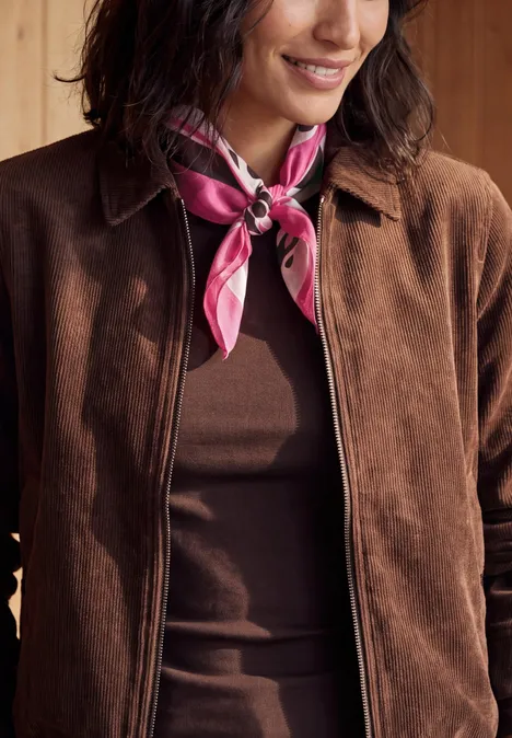 Bandana met print pink flash Person in brauner Jacke und braunem Top mit pinkem Halstuch um den Hals.