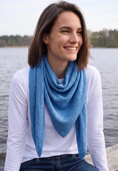 Dreieckstuch in Unifarbe north blue melange Lächelnde Frau mit blauem Dreieckstuch und weißem Shirt sitzt am Wasser, Blick zur Seite.