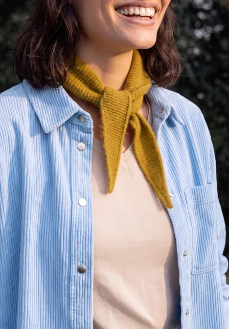 Schmaler Schal in Unifarbe golden honey melange Frau lächelt, trägt beigefarbenes Oberteil, senfgelbe Halsbinde und hellblau-weiß gestreiftes Hemdjacke.