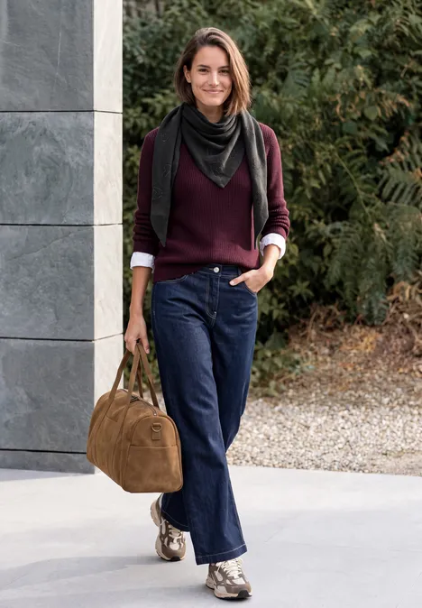 Dreieckstuch mit Glitzerdetails Black Eine lächelnde Frau in Burgunderpullover, Jeans und Halstuch, trägt eine braune Tasche und läuft draußen.