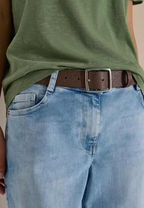 Ceinture Basic à boucle carrée Cacao Person trägt grünes T-Shirt, helle Jeans und braunen Gürtel mit eckiger Metallschnalle.