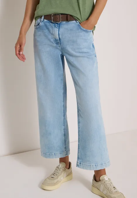 Ceinture Basic à boucle carrée Cacao Frau trägt hellblaue, lässige, weit geschnittene 7/8-Jeans und helle Sneaker.