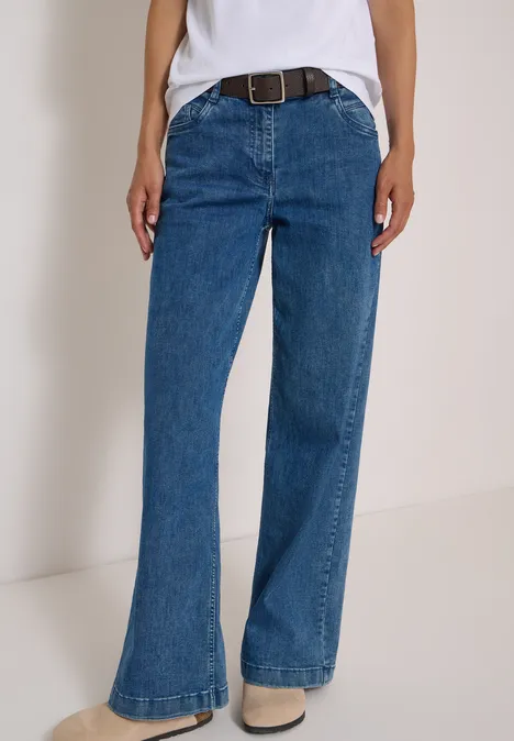 Ceinture Basic à boucle carrée Dark Brown Eine Person trägt hoch sitzende, leicht ausgestellte blaue Jeans mit Gürtel.