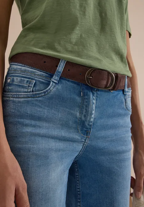 Ceinture à rayures Suede Brown Nahaufnahme einer Person mit grünem Oberteil, blauen Jeans und braunem Gürtel.