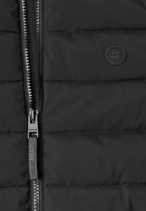 Nahaufnahme einer schwarzen Steppjacke mit Reißverschluss und CMP-Logo.