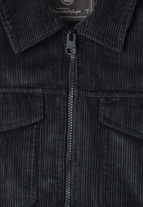 Schwarze Cordjacke mit Reißverschluss, Brusttaschen und Kragen aus Cordgewebe.