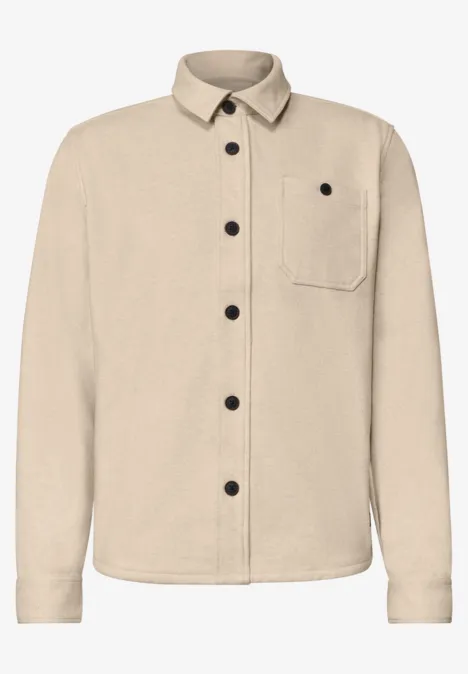 Beiger Overshirt mit langen Ärmeln, Brusttasche und schwarzen Knöpfen.