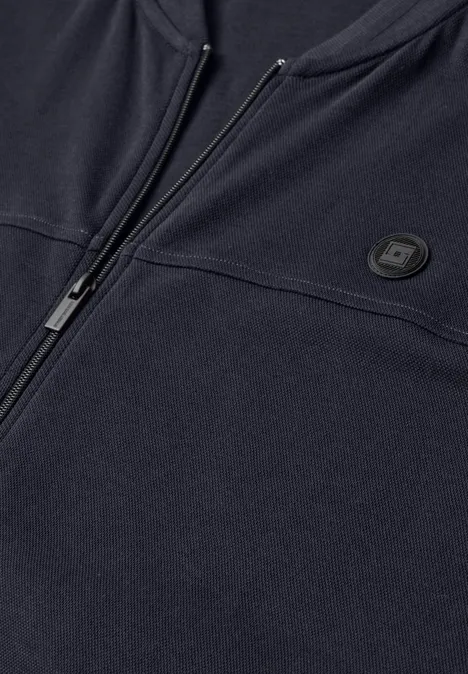 Blouson en piqué double face à fermeture zip dark ink blue Nahansicht eines dunkelblauen Reißverschluss-Sweatshirts mit rundem Logo auf der Brust.