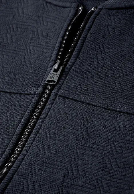 Veste bleu foncé à fermeture éclair et motif géométrique sur le tissu