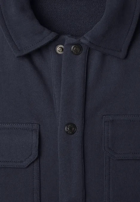 Veste bleu marine avec col chemise, deux poches poitrine à rabat et fermeture boutonnée.