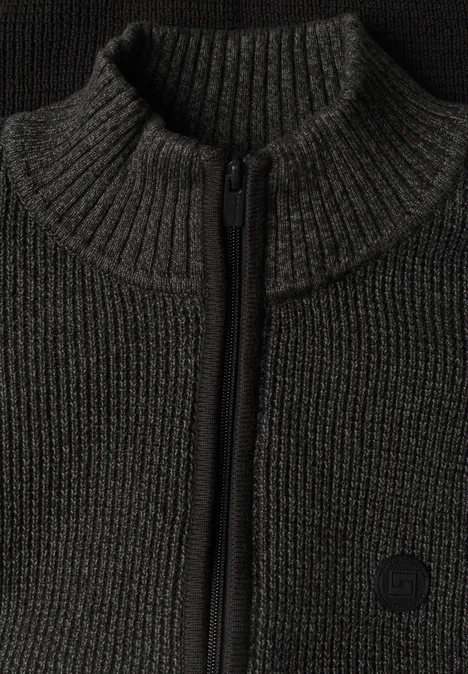 Gros plan d'un pull en maille sombre à col montant et fermeture éclair.