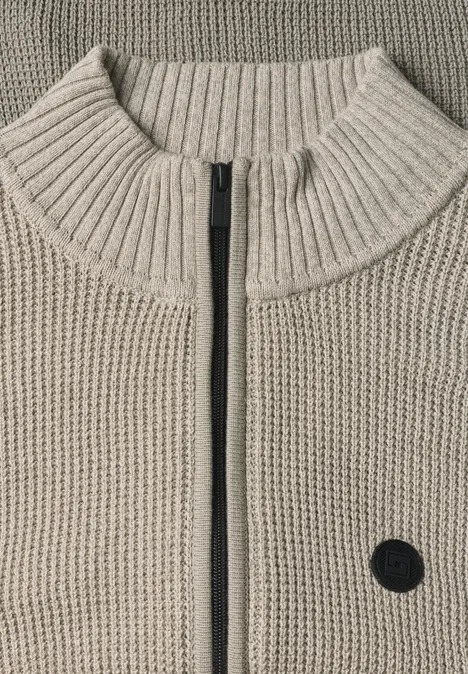 Kardigan z elementami w stylu mouliné i zamkiem błyskawicznym bright beige melange Beżowy sweter z grubego splotu, stójką, centralnym zamkiem i małą czarną okrągłą naszywką z przodu.