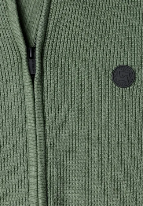Olivegrüne, fein gerippte Strickjacke mit durchgehendem Reißverschluss und dezentem Logo-Patch.