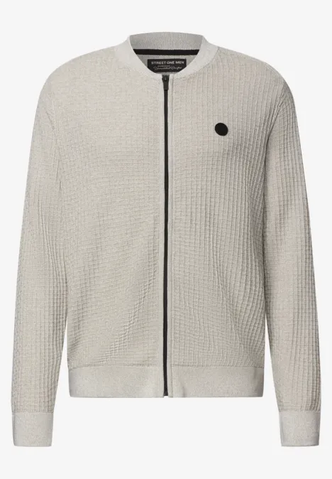 Lichtgrijze cardigan in wafeldraad met ritsluiting en klein zwart logo op de borst.