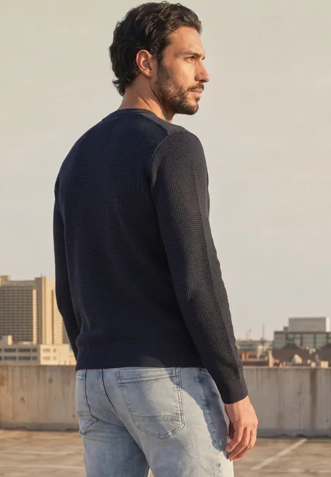 Pullover mit Rundhals und Schulterdetail dark basic blue Ein Mann steht auf einem Dach, trägt Jeans und Pullover und blickt über die Stadt.
