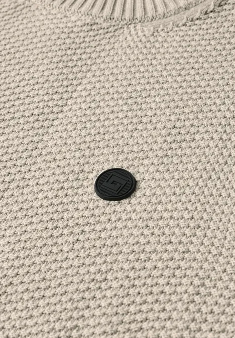 Sweter w stylu melanżowym z strukturą bright beige melange Beżowy sweter z waflowym splotem, z małym, okrągłym czarnym logo na środku.