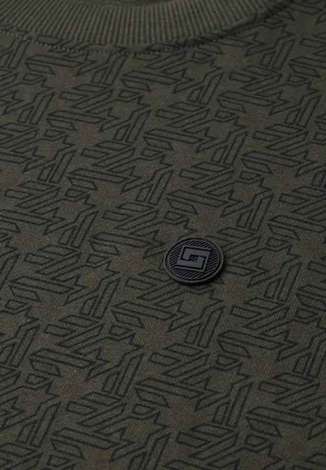 Grünes T-Shirt mit dezentem Allover-Muster und runder Logo-Plakette in der Mitte.