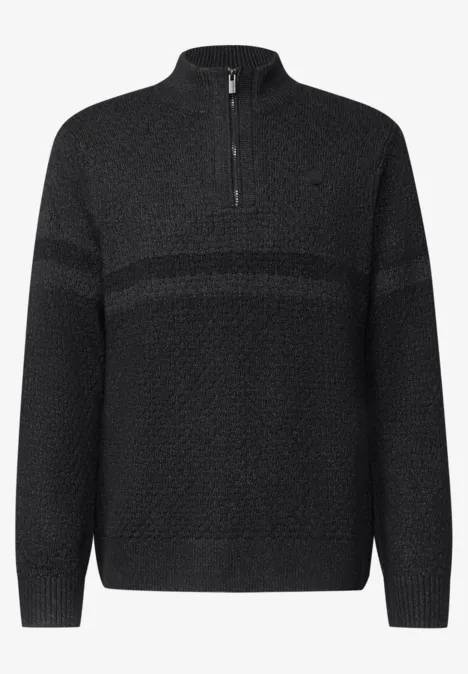 Schwarzer Strickpullover mit halbem Reißverschluss und feinem Muster.