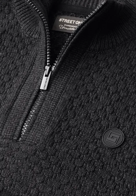 Schwarzer Strickpullover mit halbem Reißverschluss und Logo-Patch.